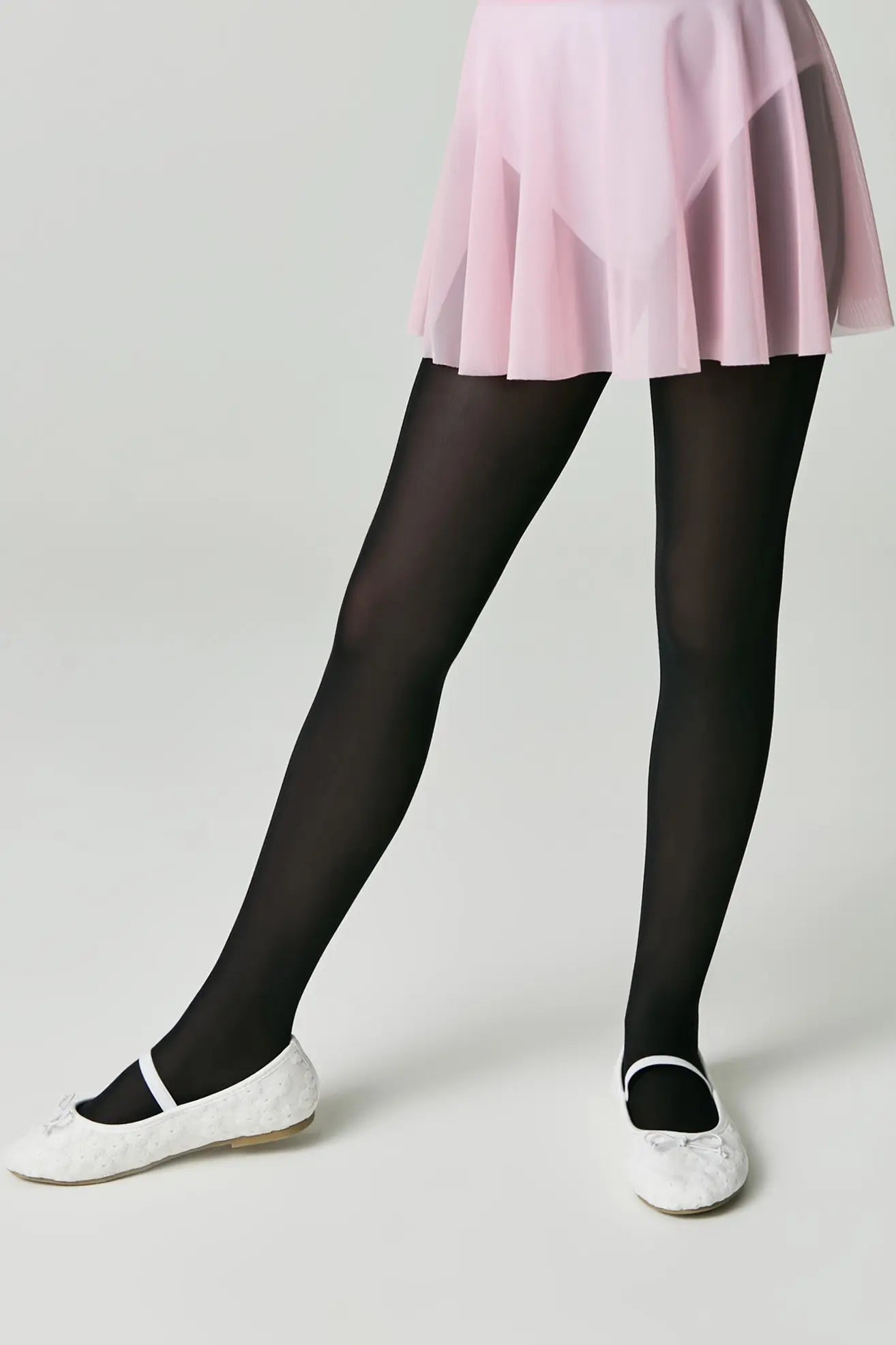 Person wearing black tights and a pink skirt on a white background #color_nero-black