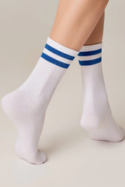 White socks with blue stripes worn by a person on a beige background #color_blue