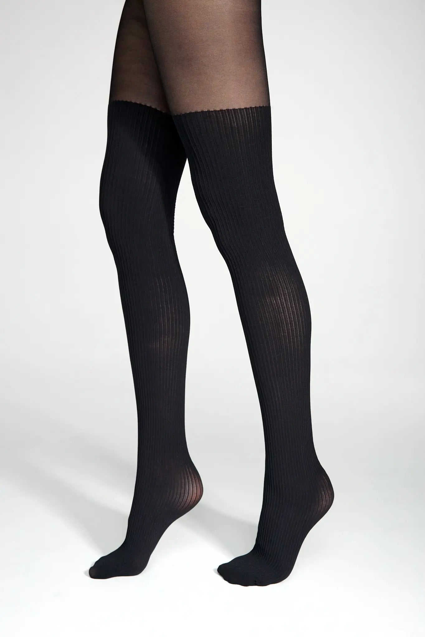 Black knee-high socks worn by a person on a white background