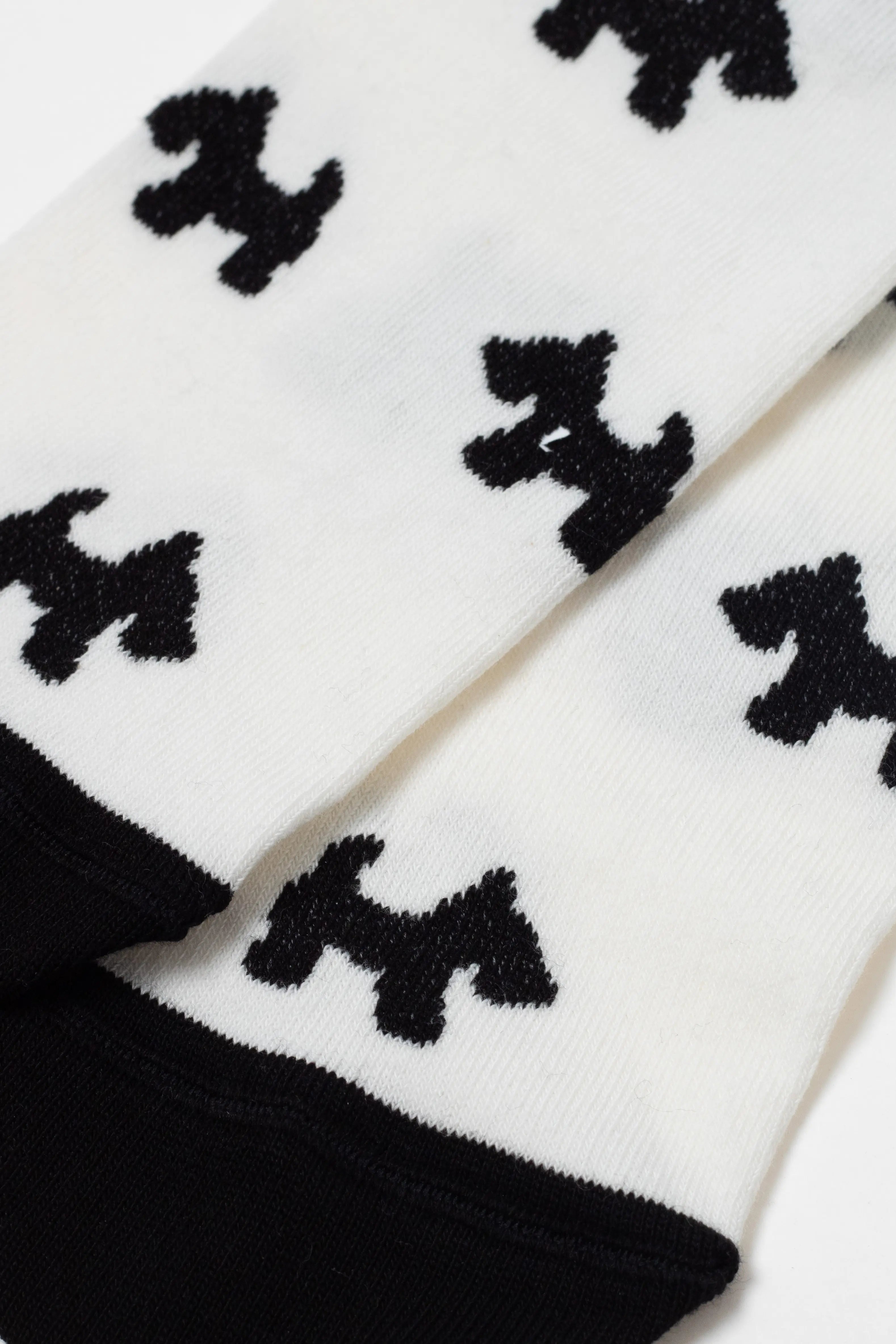 White socks with black dog pattern on a white background #color_milk