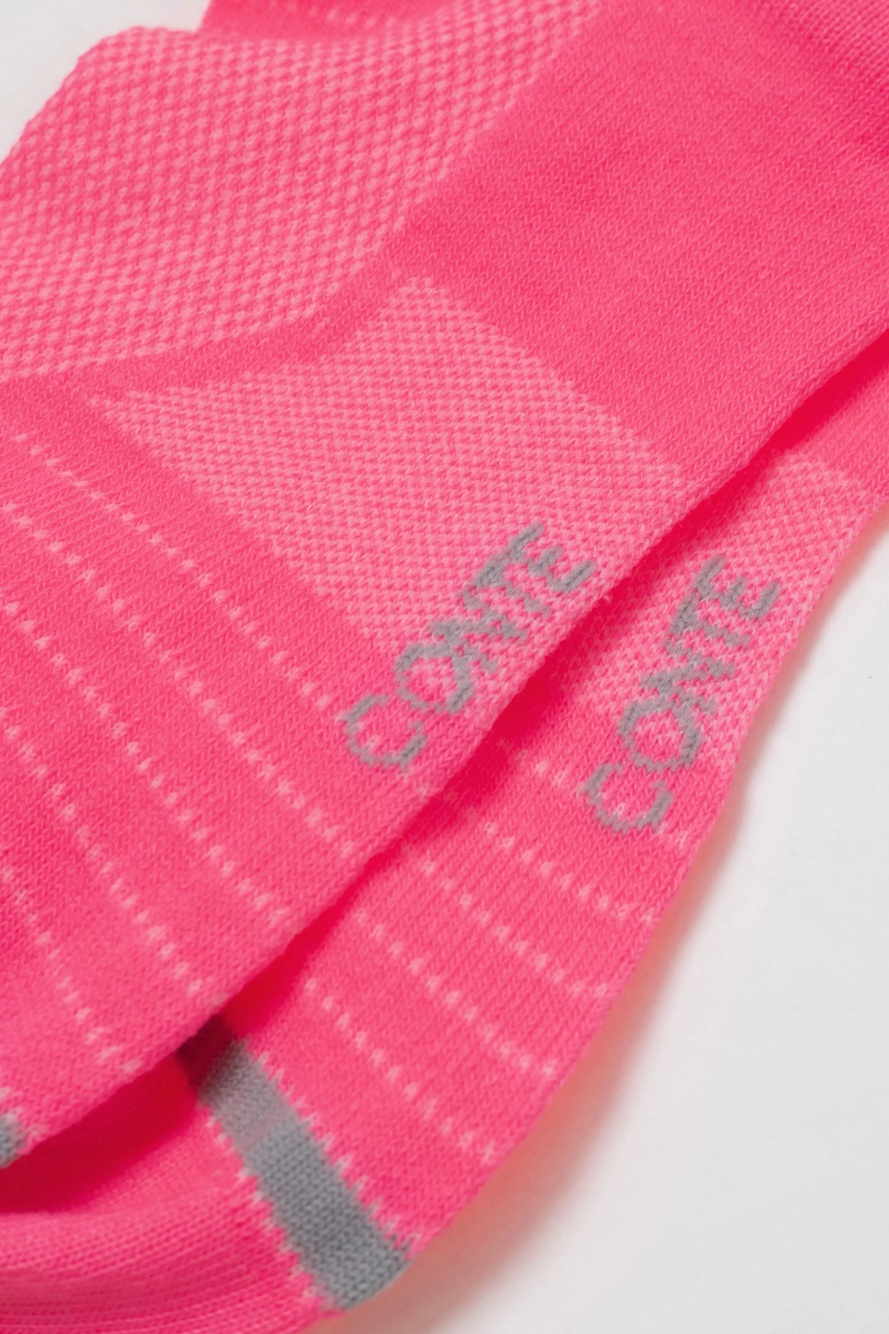 Close-up of pink socks with 'Cotswold' branding on a light gray background #color_pink