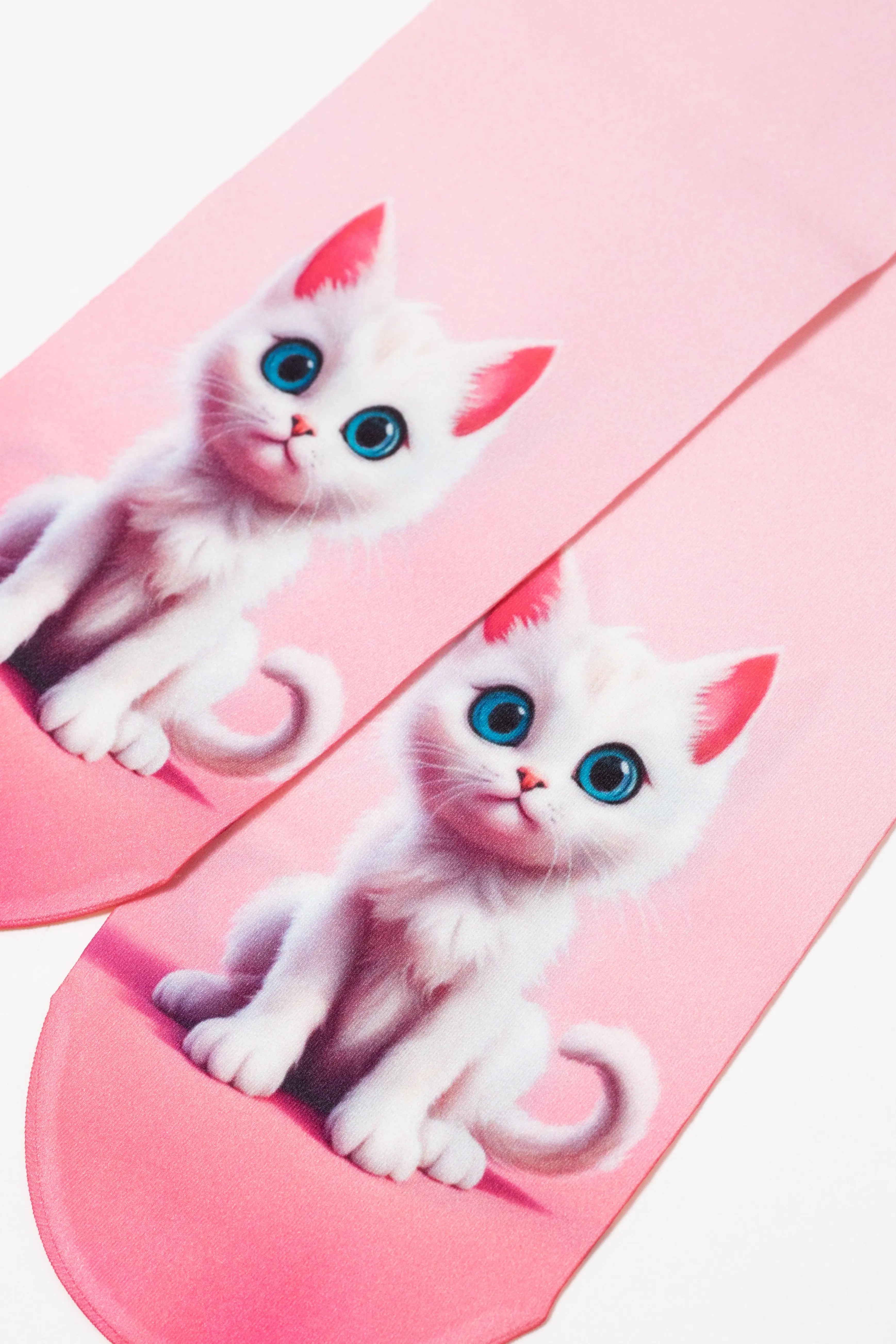 Pink slippers with white cat designs on a pink background