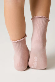 Pink socks with ruffled top worn by a person on a light background #color_ash-pink