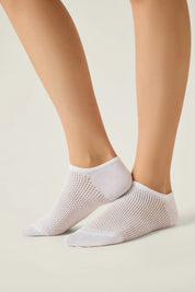 White socks worn by a person on a light background #color_white