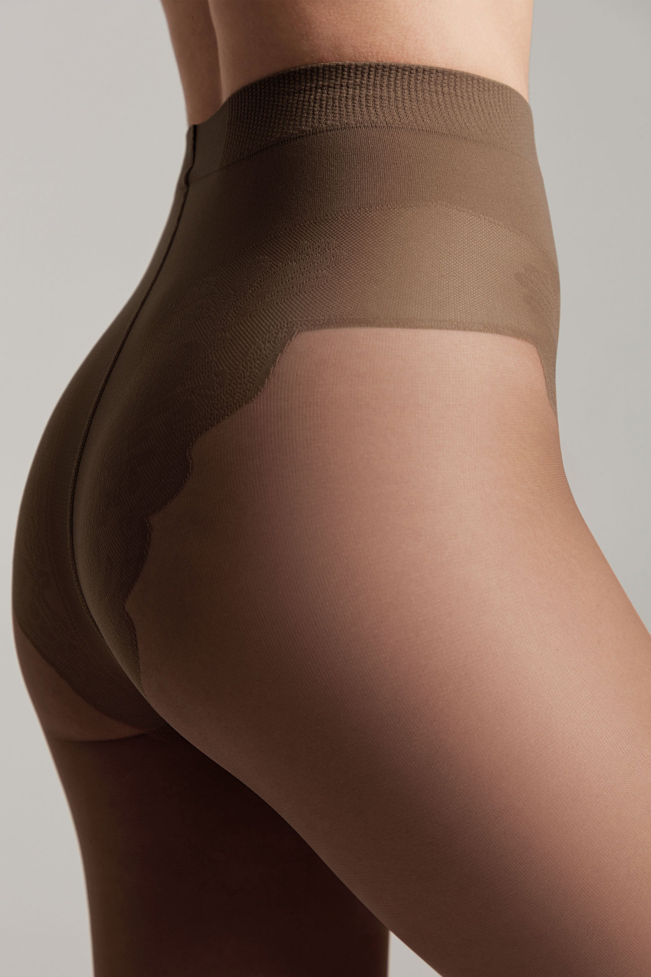 Brown tights worn by a person on a plain background