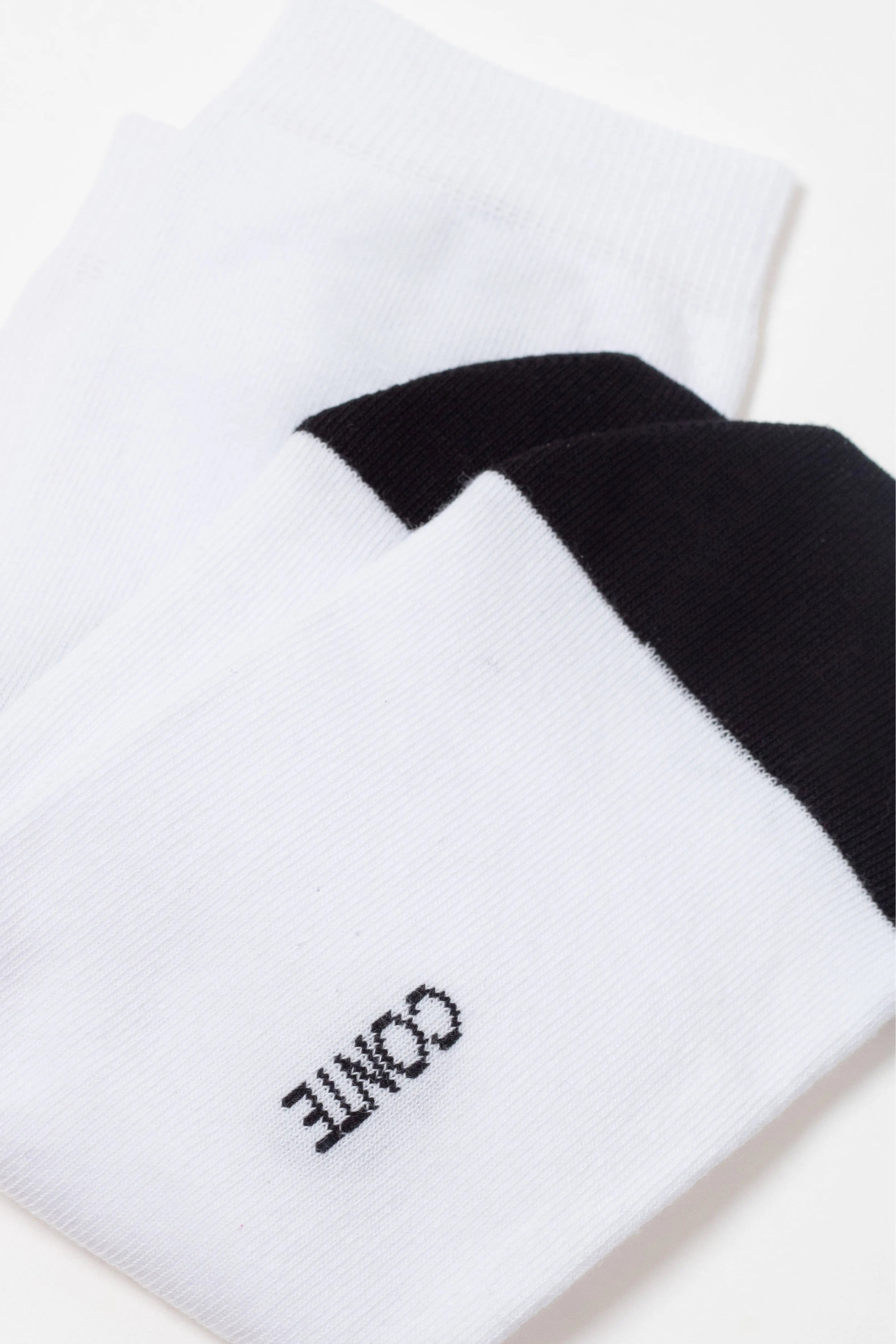 White socks with black accents and 'Conte' branding on a white background