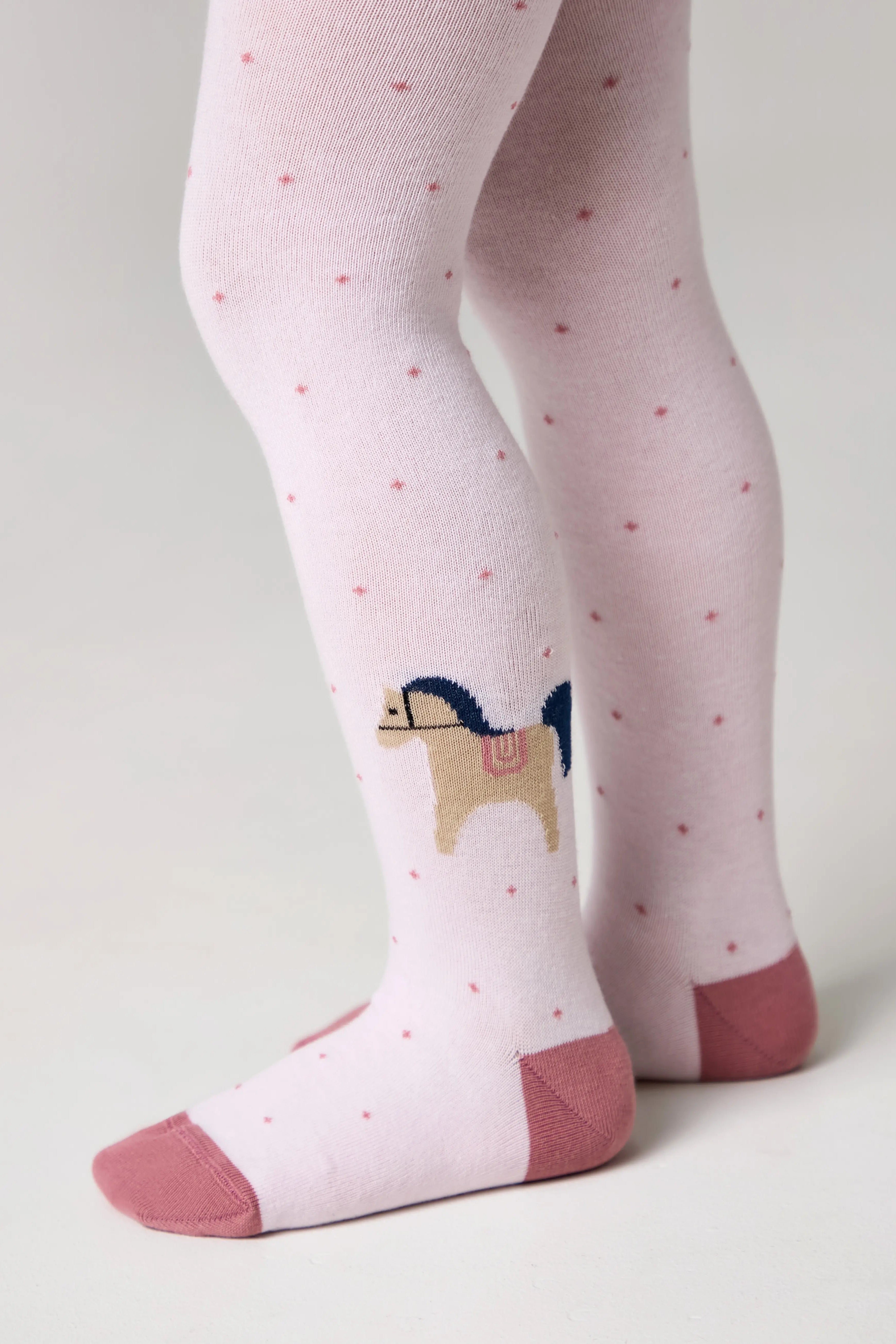 Pink tights with a horse design and matching socks on a light gray background #color_light-pink
