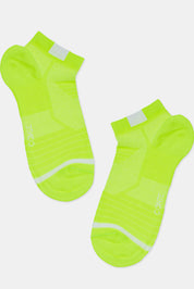 Pair of neon green socks with white accents on a light gray background #color_lime-green