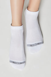 White socks with a brand logo on a light gray background #color_white