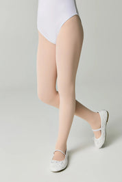 Person wearing beige sheer stockings with white shoes on a light gray background #color_pink-ballet