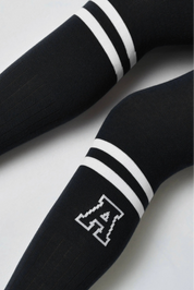 Black hockey stick with white stripes and a logo on a light gray background