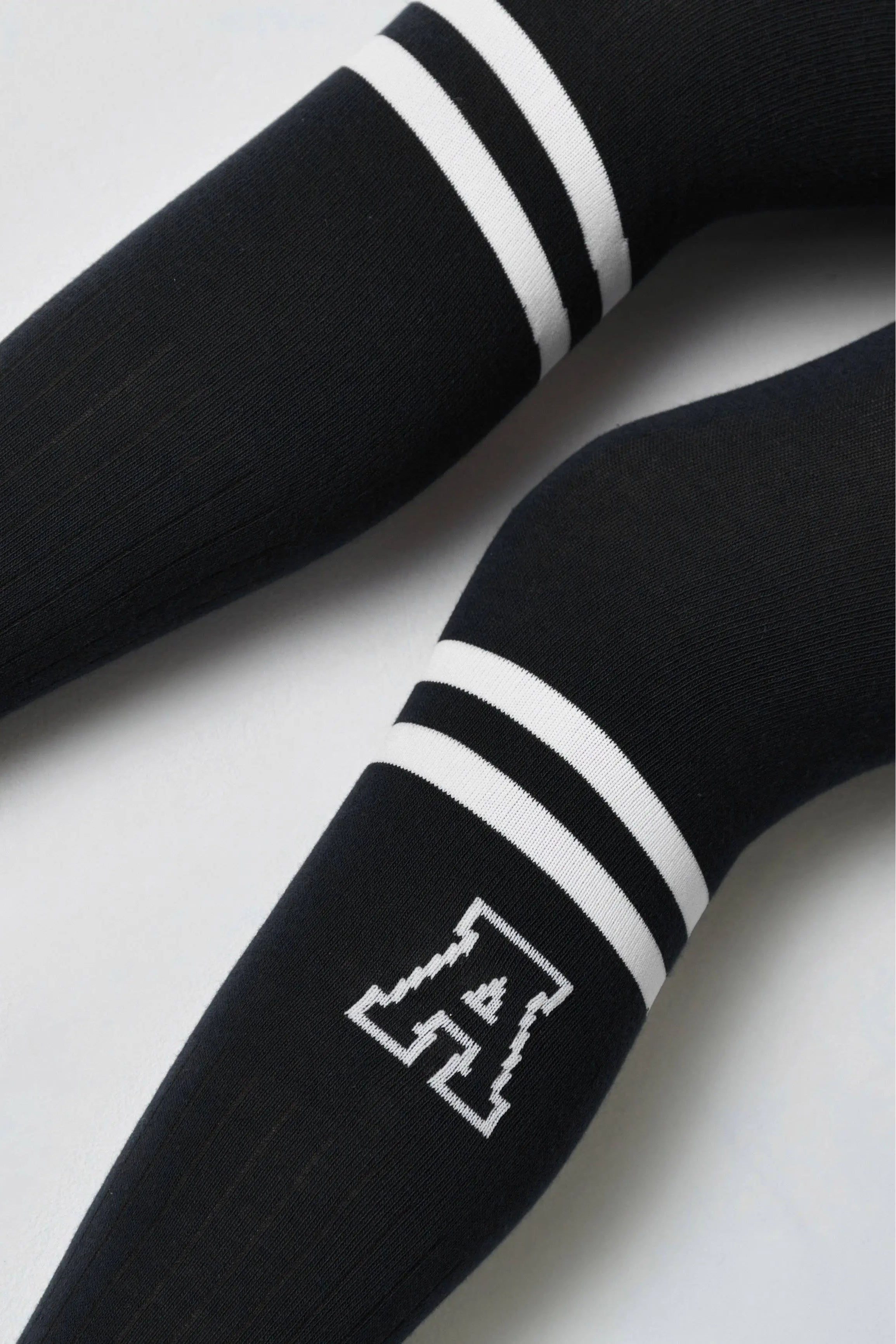 Black hockey stick with white stripes and a logo on a light gray background