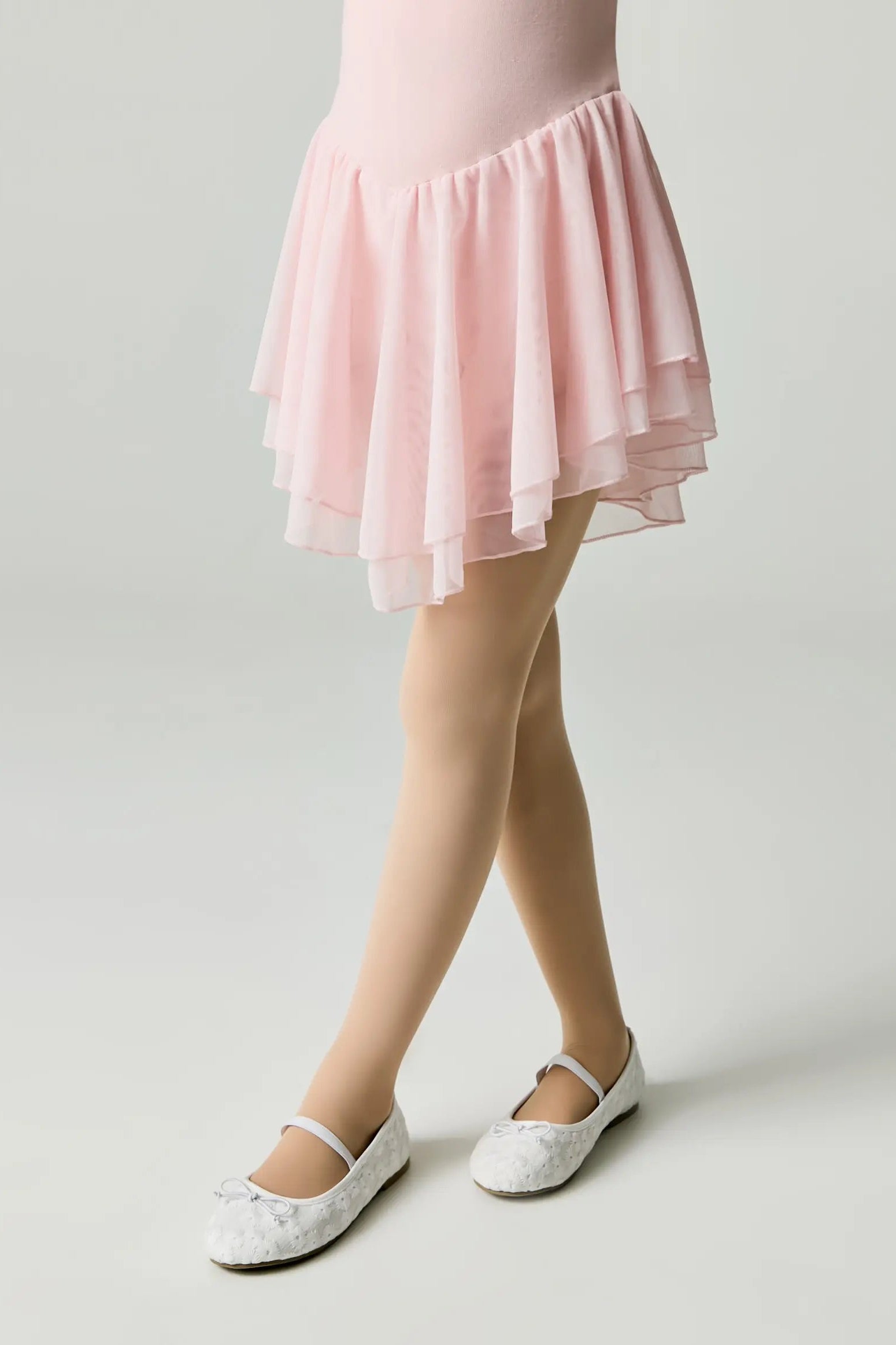 Person wearing a pink skirt with white shoes on a light background #color_natural-nude