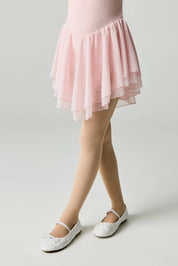 Person wearing a pink skirt with white shoes on a light background #color_natural-nude