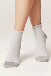 Gray ankle socks worn by a person on a white background #color_gray