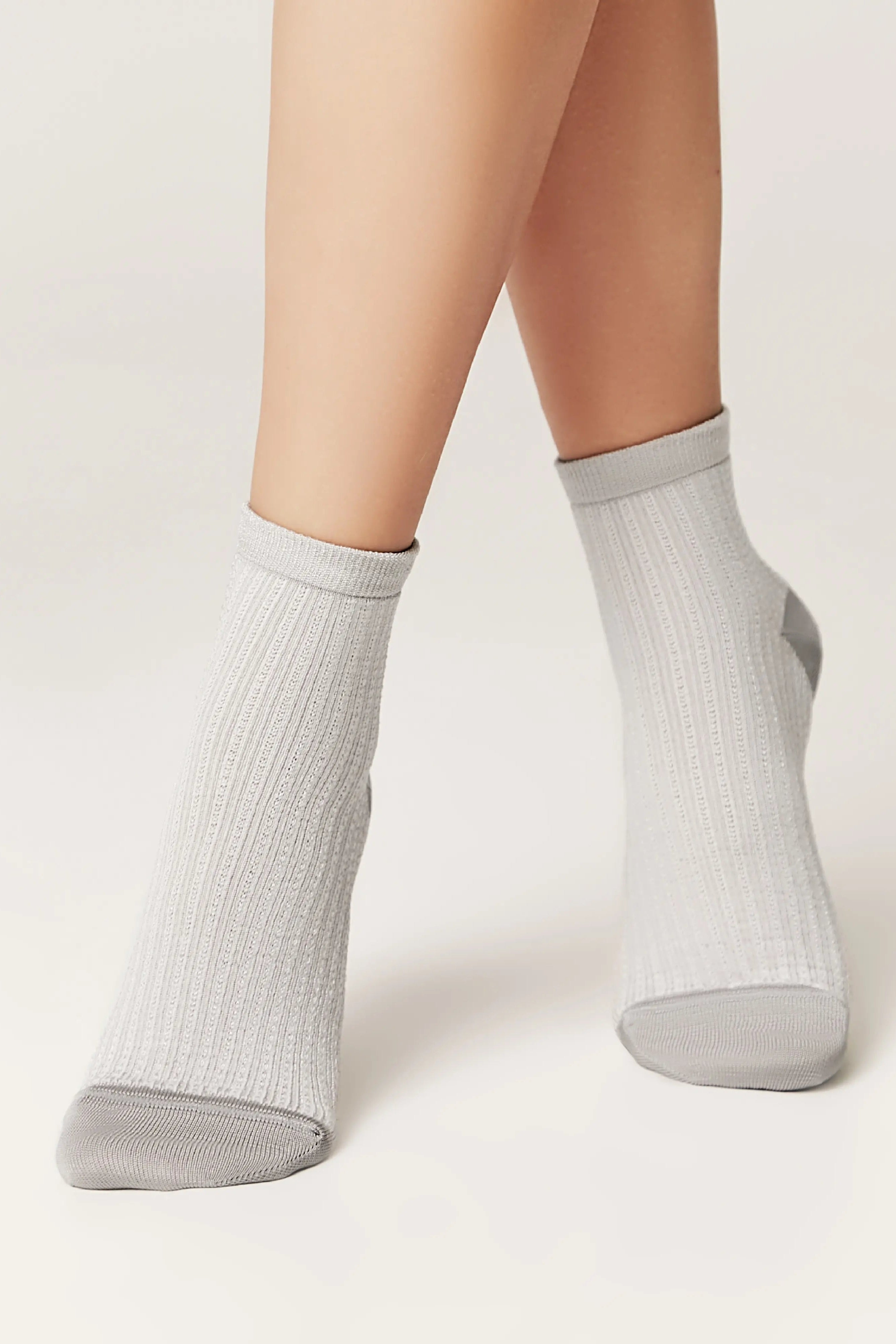 Gray ankle socks worn by a person on a white background #color_gray