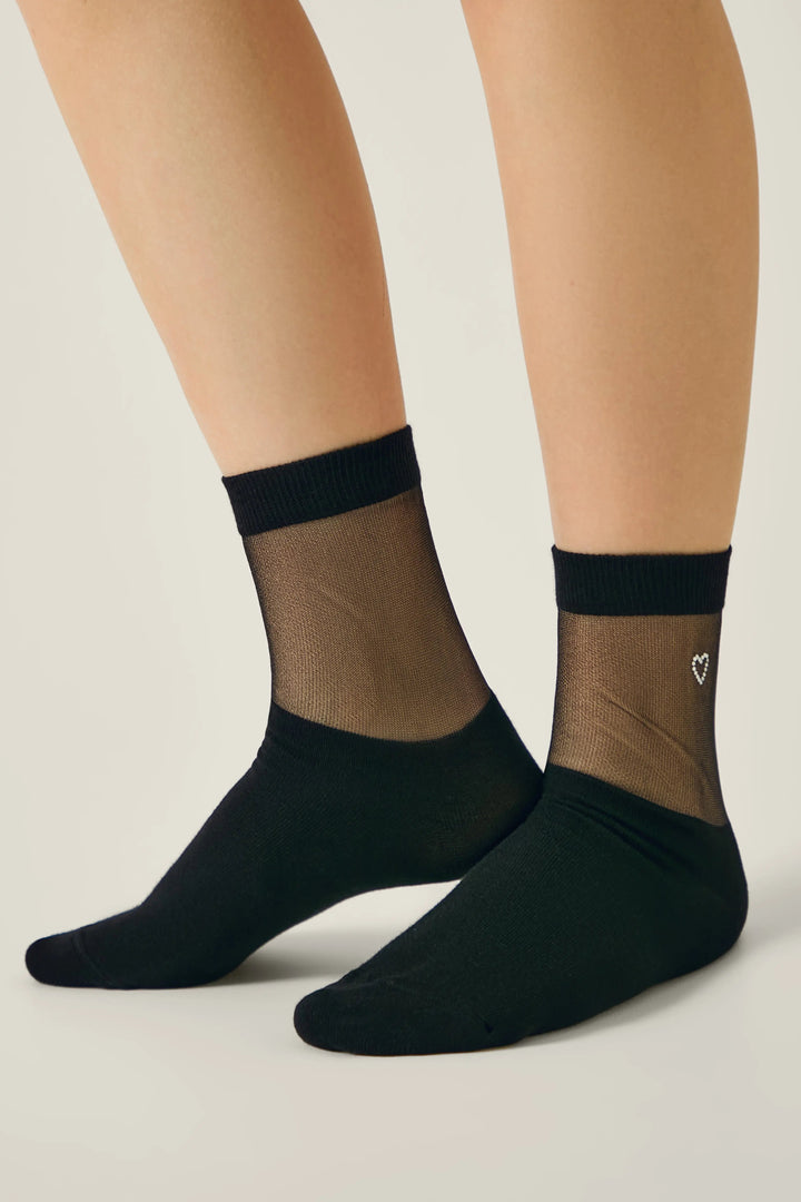 Black sheer socks with a heart detail on a neutral background #color_black