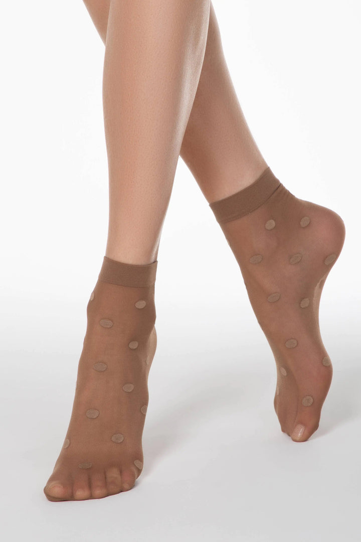 Brown sheer socks with dot pattern worn by a person on a white background #color_bronz-tan