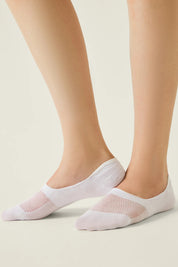 White socks with mesh design worn by a person on a light background