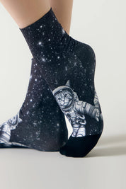 Black socks with cat astronaut design on a light gray background