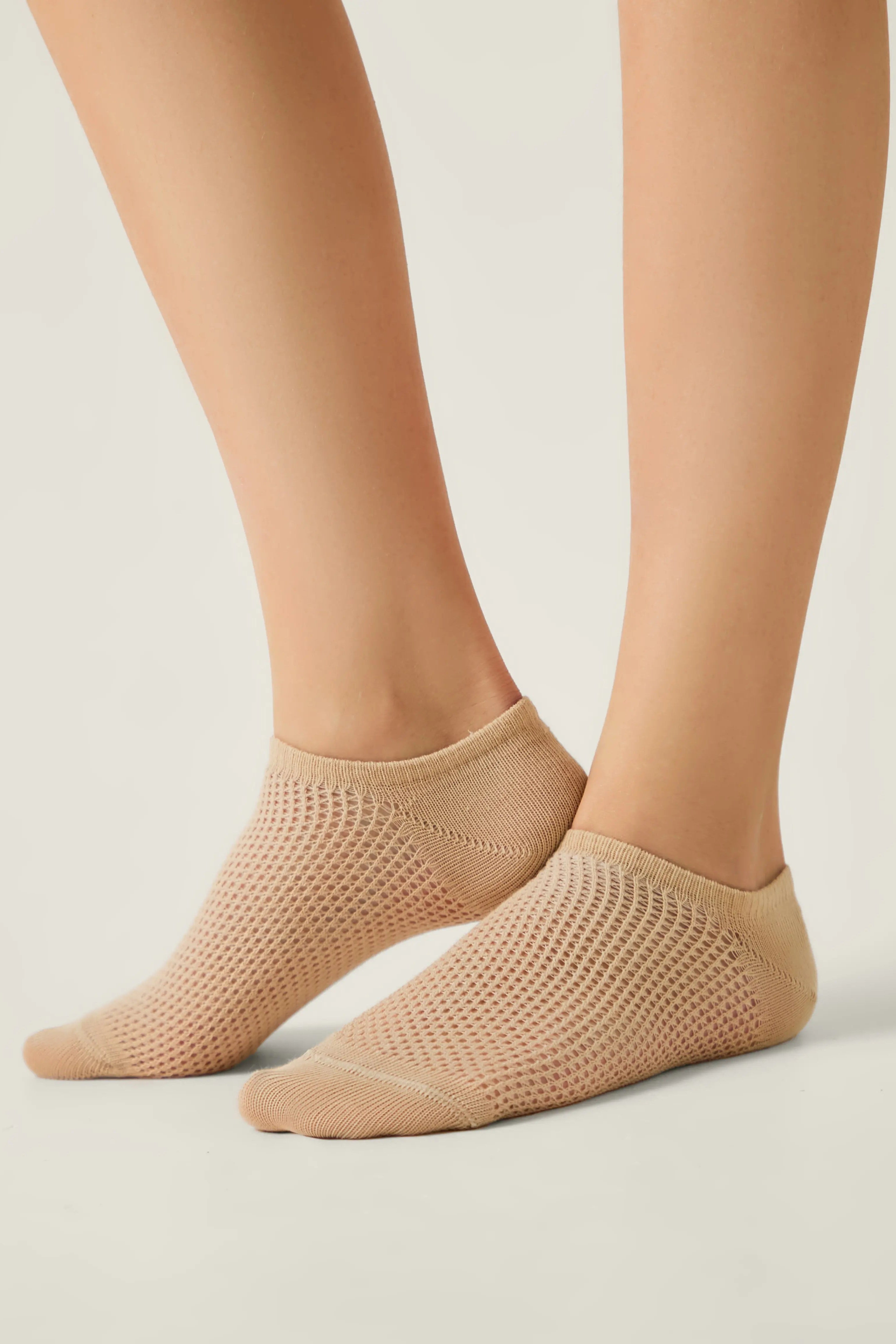 Beige socks worn by a person on a light gray background #color_beige