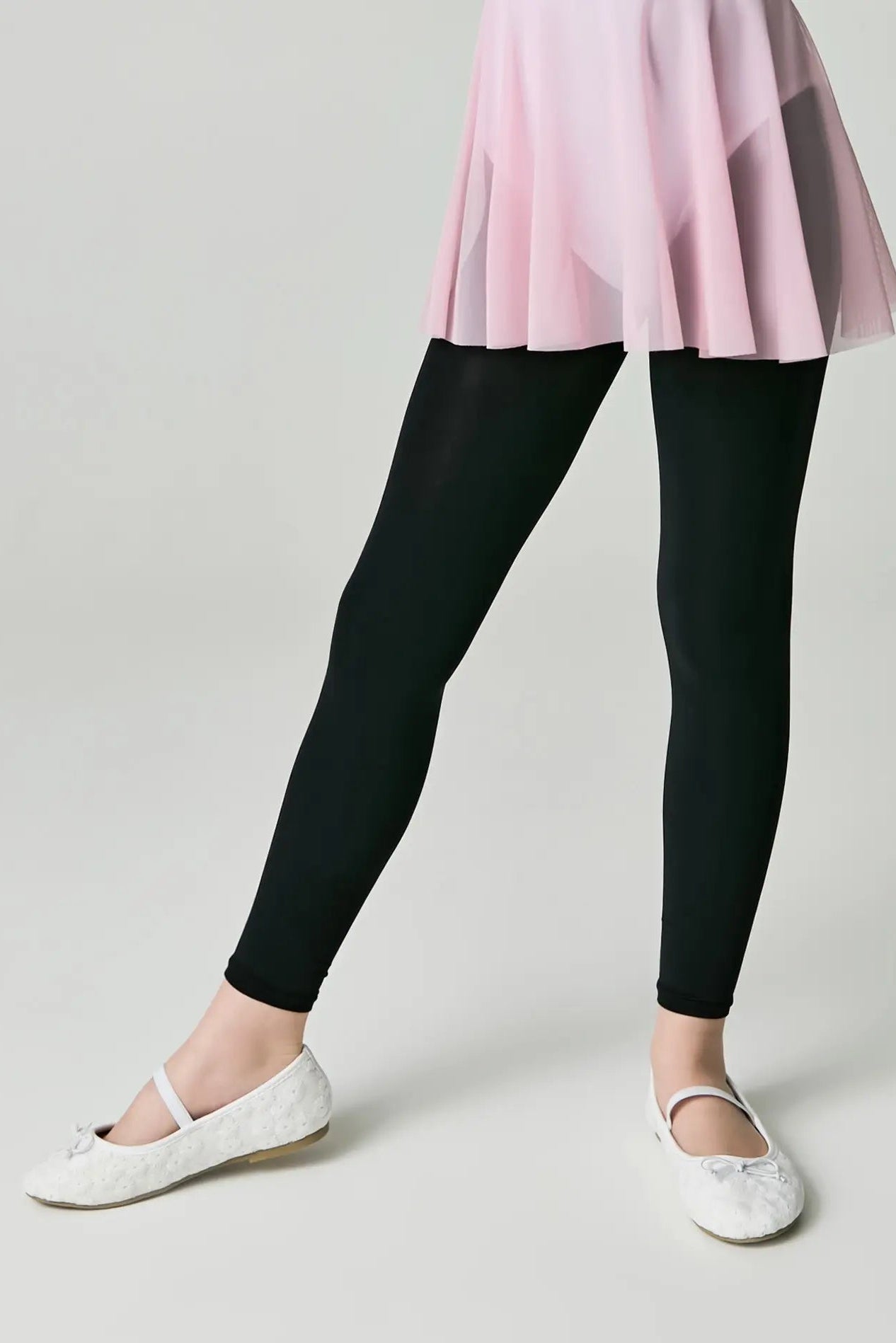 Person wearing black leggings and a pink skirt on a plain background #color_nero-black