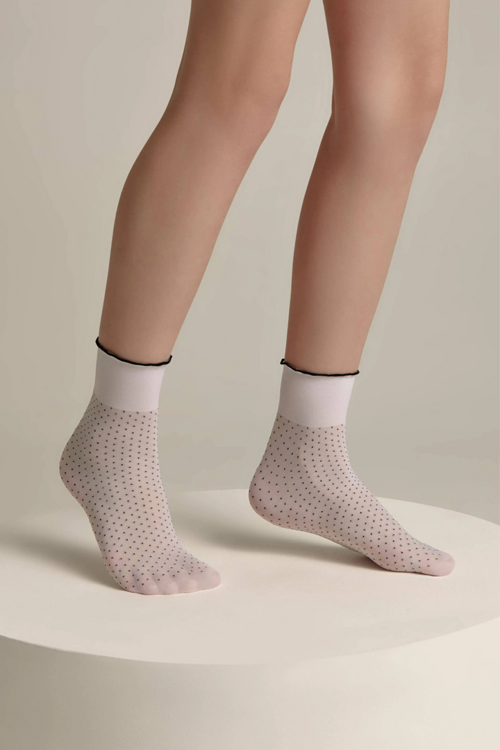 Person wearing light gray socks with a subtle pattern on a neutral background