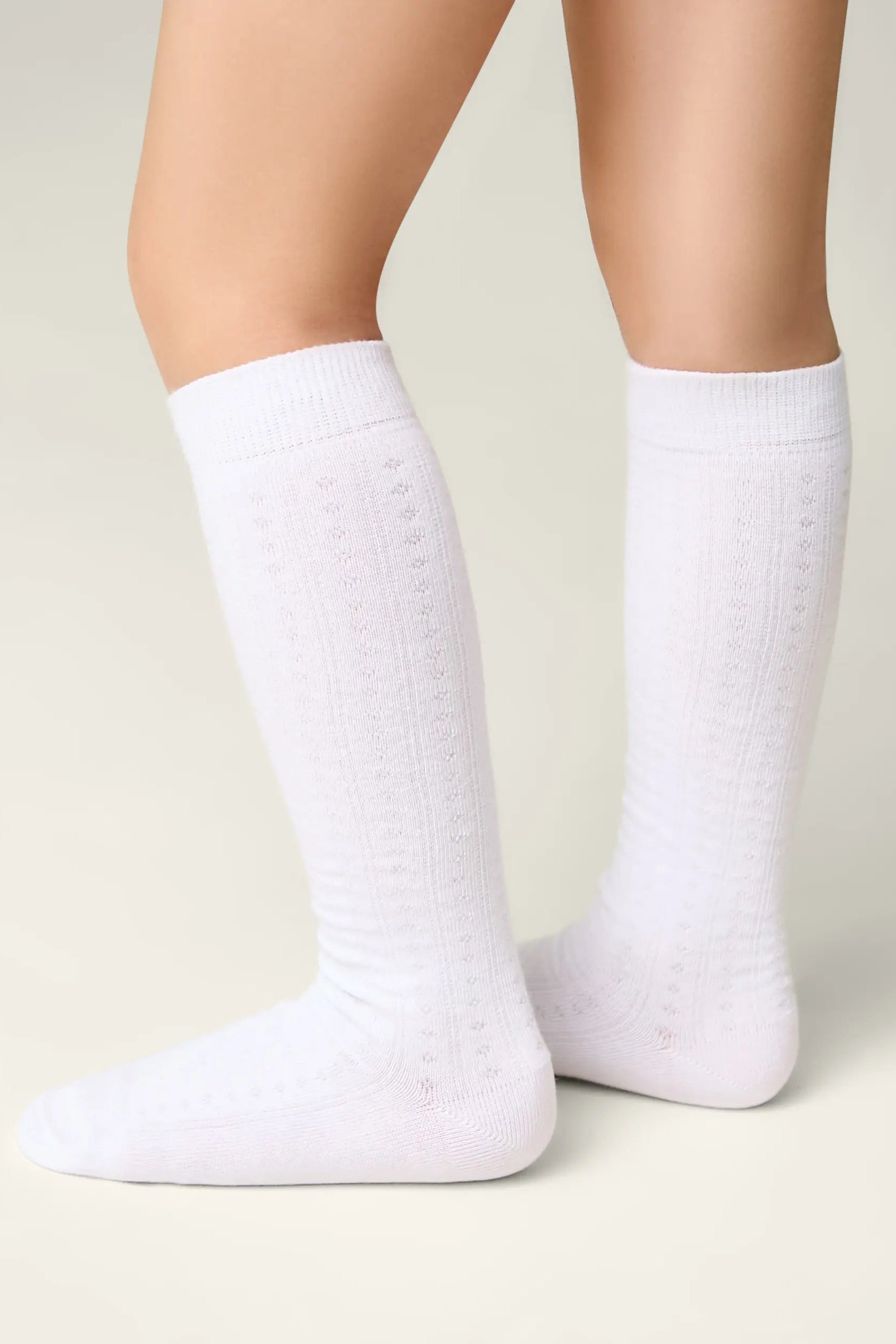 White socks worn by a person on a light background #color_white