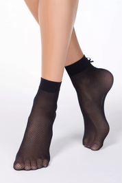 Black fishnet socks worn by a person on a white background #color_nero-black