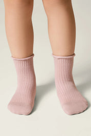 Pink socks worn by a person on a neutral background #color_ash-pink