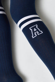 Navy knee-high socks with a white logo on a light gray background