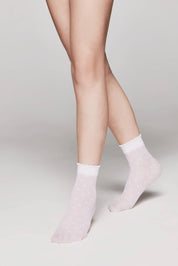 Light pink socks worn by a person on a plain background #color_bianco