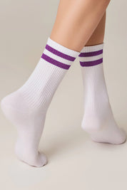 White socks with purple stripes worn by a person on a beige background #color_lilac