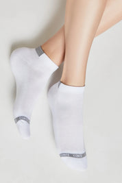 White socks with gray accents worn by a person on a light background #color_white