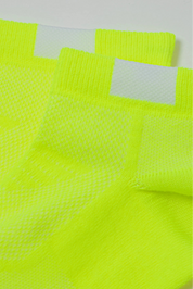 Close-up of bright yellow socks with mesh design on a white background #color_lime-green