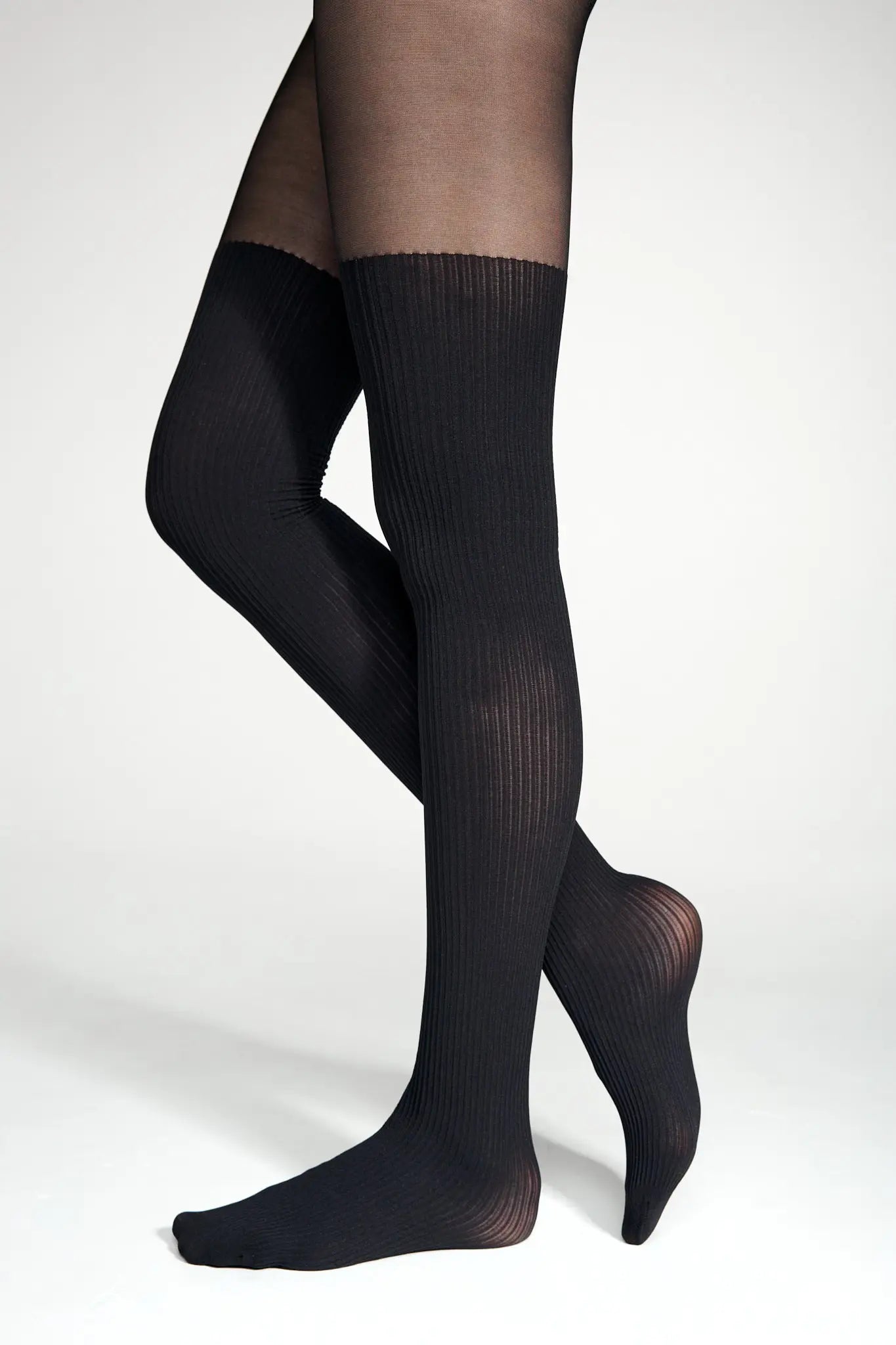 Black knee-high socks worn by a person on a white background