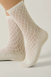 Beige lace socks on a light background 