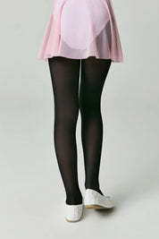 Person wearing black tights and white shoes on a plain background #color_nero-black