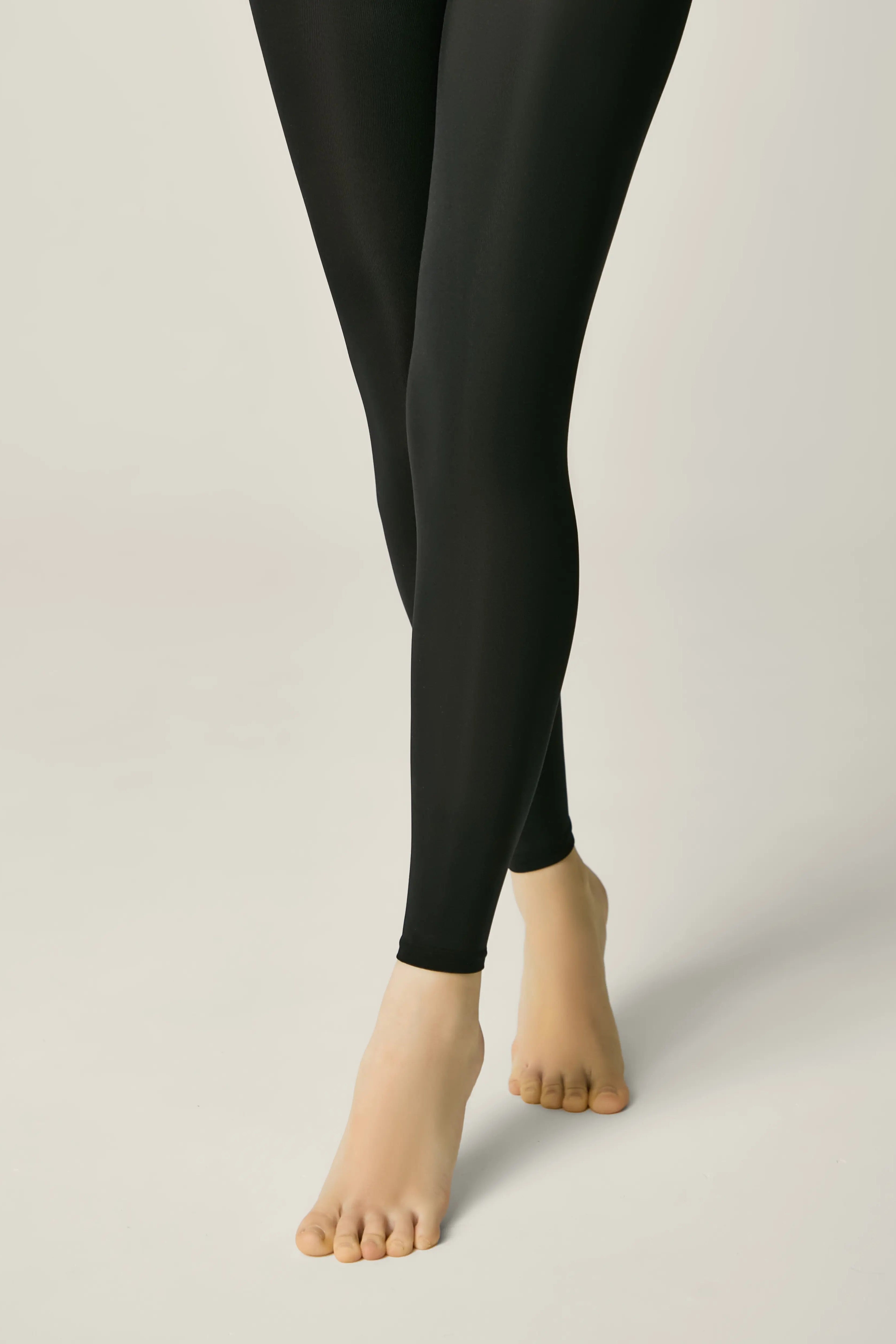 Black leggings worn by a person on a plain background #color_nero-black