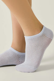 Light gray ankle socks worn by a person on a neutral background #color_pale-purple