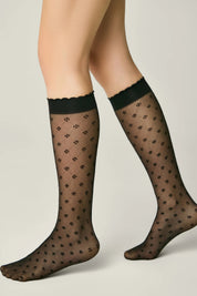 Black patterned sheer socks worn by a person on a plain background #color_nero-black