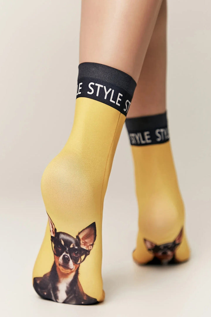 Yellow socks with dog print and black cuffs on a neutral background