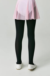 Person wearing a pink top and black leggings on a plain background #color_nero-black