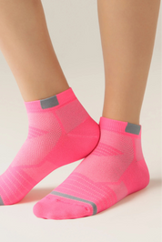 Pink socks with gray accents worn by a person on a light background #color_pink