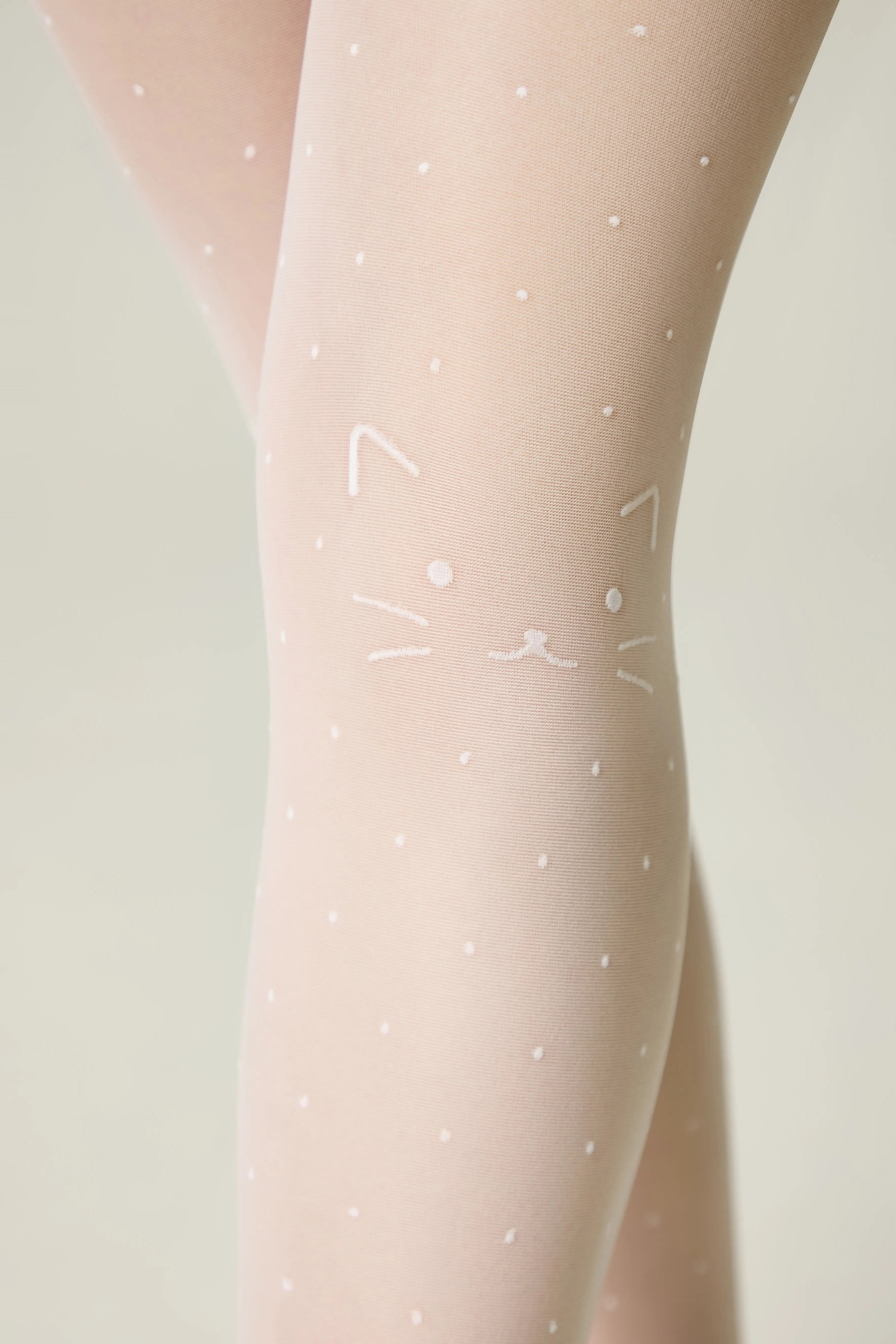 Sheer tights with white polka dots and triangle patterns on a light background #color_bianco