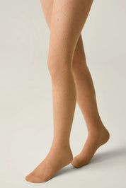 Beige tights worn by a person on a plain background #color_natural-nude