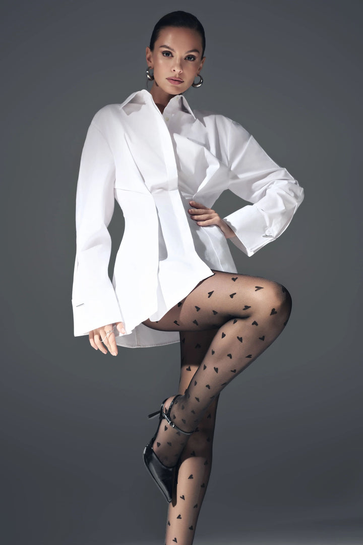 Woman wearing a white shirt and black patterned stockings against a gray background #color_nero-black