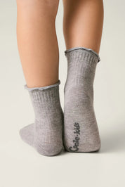 Gray socks worn by a person on a light gray background #color_gray