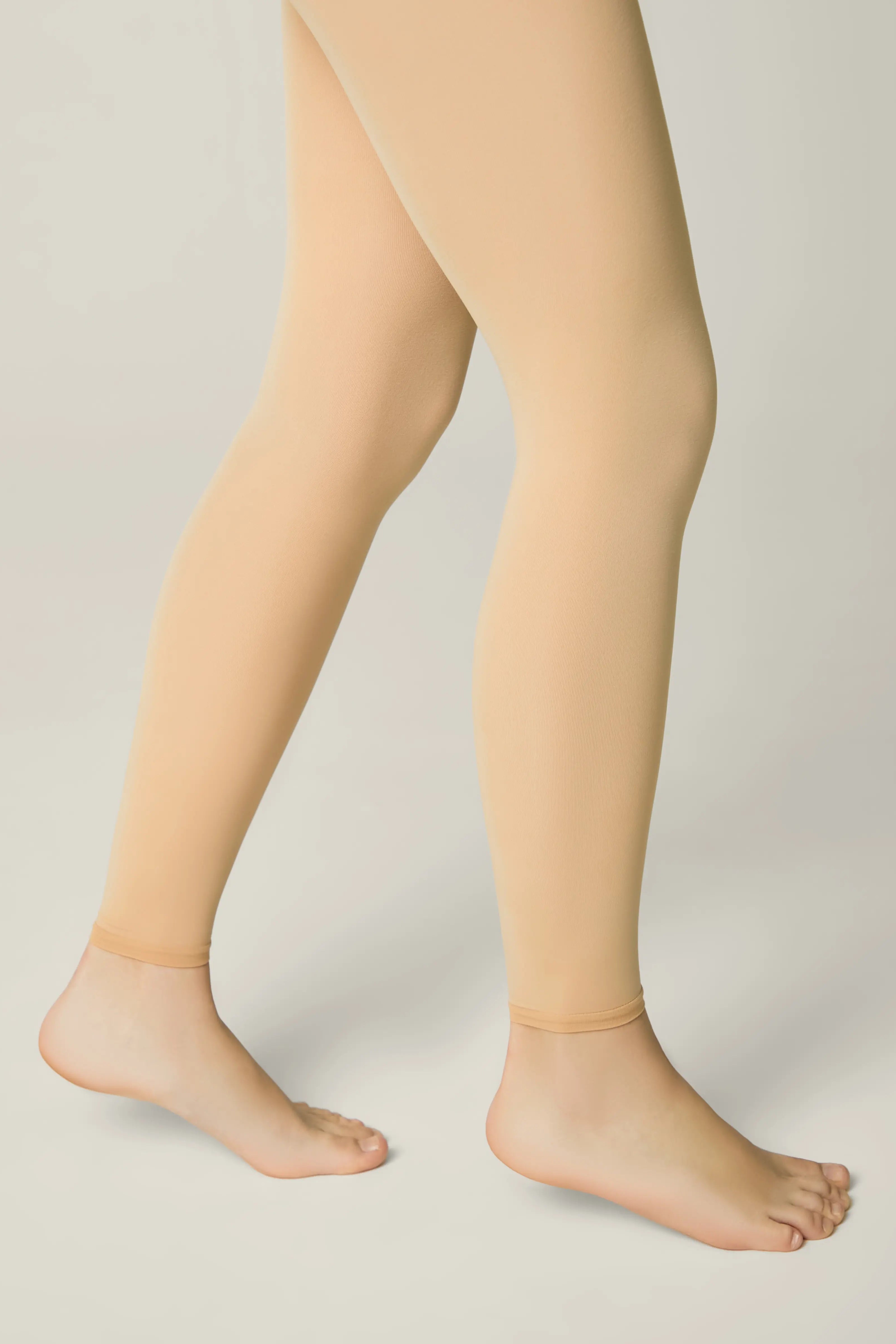 Beige tights worn by a person on a plain background #color_natural-nude
