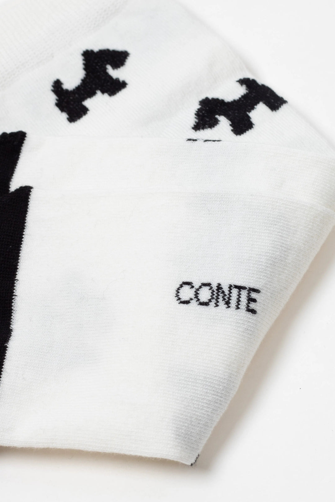 White scarf with black patterns and 'CONTE' branding on a white background #color_milk